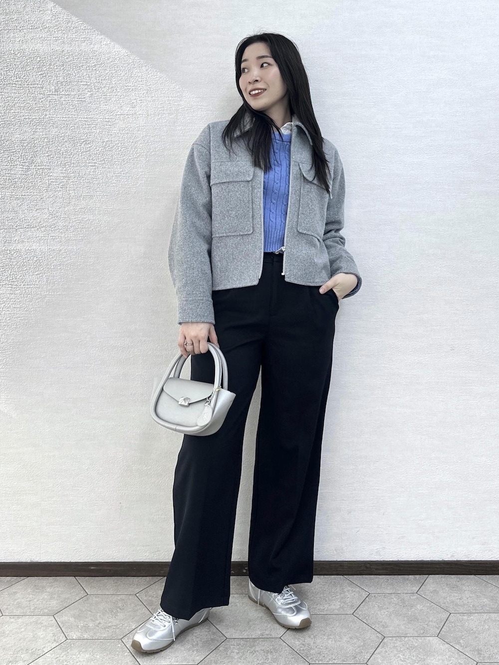 グレー系のブルゾン、ブルー系のその他パンツ、シルバー系のショルダーバッグを着用したレディースの冬コーディネートの1枚目の写真
