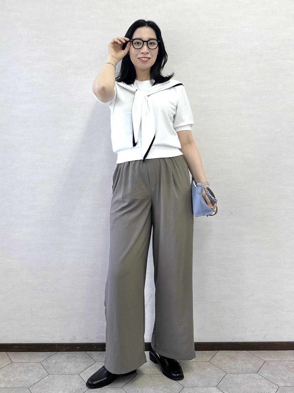 グレー系のショルダーバッグ、グリーン系のその他パンツ、ホワイト系のニット/セーターを着用したレディースの夏コーディネートの1枚目の写真