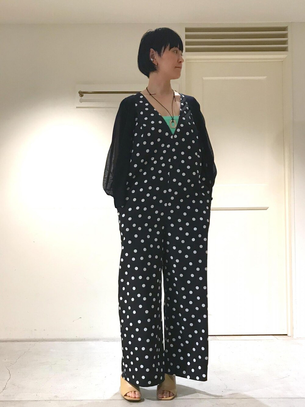 ホワイト系のサンダル、グリーン系のチューブトップ、ブラック系のカーディガン/ボレロを着用したレディースの夏コーディネートの1枚目の写真