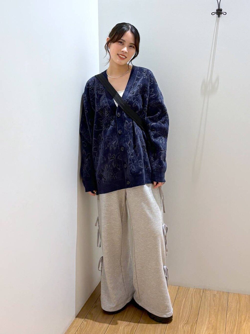 ブラック系のスニーカー、ブラック系のショルダーバッグ、グレー系のスウェットパンツを着用したレディースの秋コーディネートの1枚目の写真