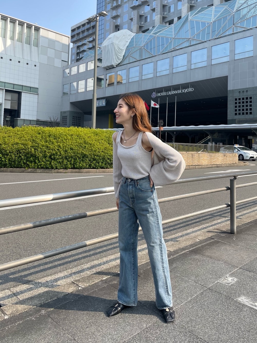 ブルー系のデニムパンツ、ブラック系のパンプス、ホワイト系のニット/セーターを着用したレディースの春コーディネートの1枚目の写真