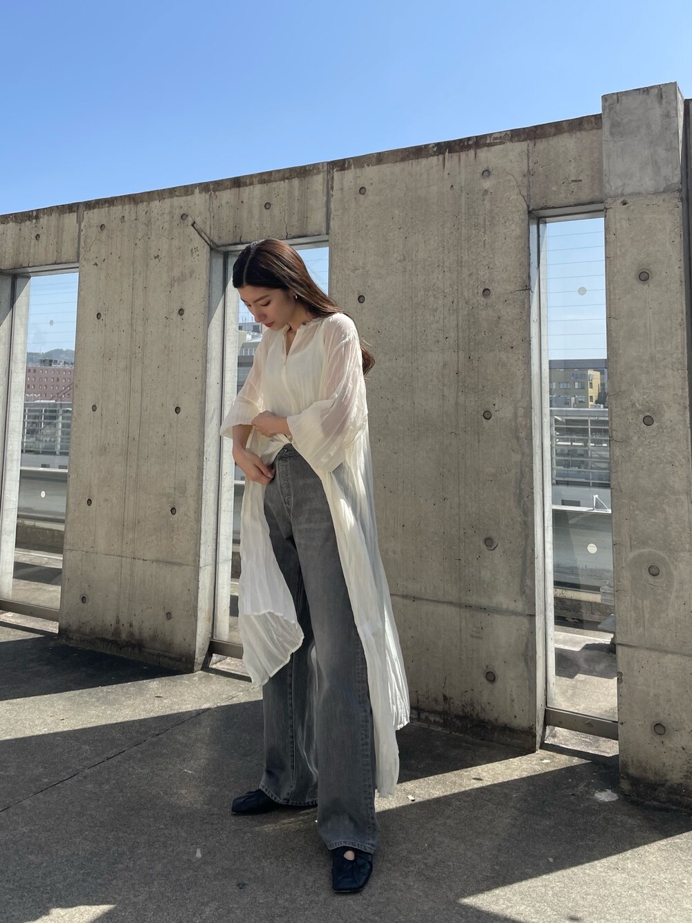 ホワイト系のワンピース、ホワイト系のタンクトップ、ブラック系のデニムパンツを着用したレディースの春コーディネートの1枚目の写真