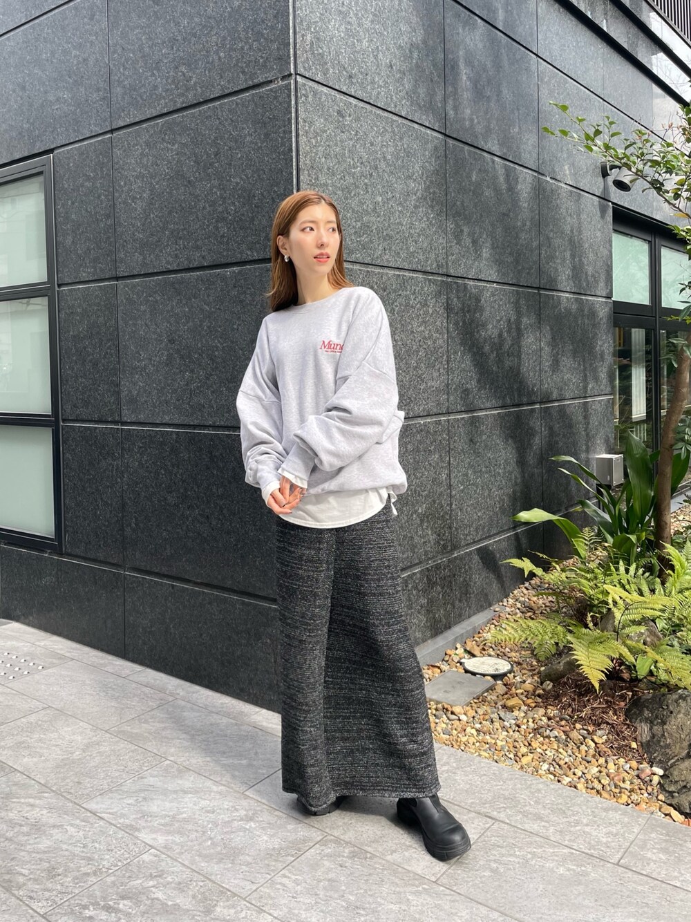 グレー系のスウェット、ホワイト系のTシャツ/カットソー、グレー系のスカートを着用したレディースの冬コーディネートの1枚目の写真