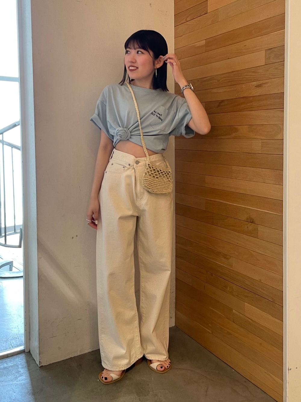 ブルー系のTシャツ/カットソー、ホワイト系のサンダル、ベージュ系のショルダーバッグを着用したレディースの春コーディネートの1枚目の写真