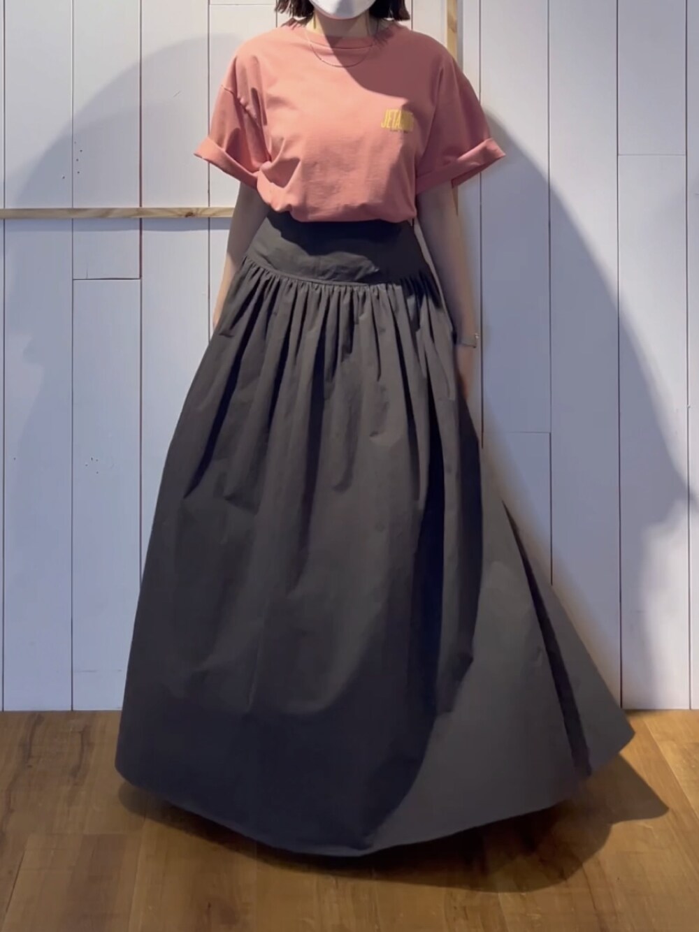 ピンク系のTシャツ/カットソー、グレー系のスカートを着用したレディースの春コーディネートの1枚目の写真