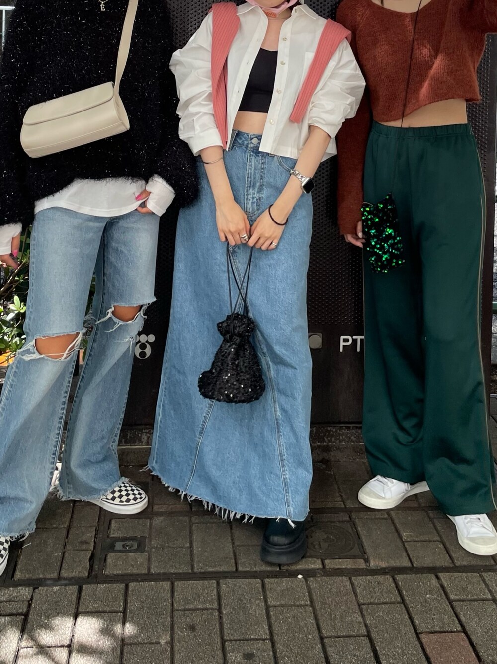 ブラック系のブーツ、ブルー系のデニムスカート、ブラック系のハンドバッグを着用したレディースの秋コーディネートの1枚目の写真