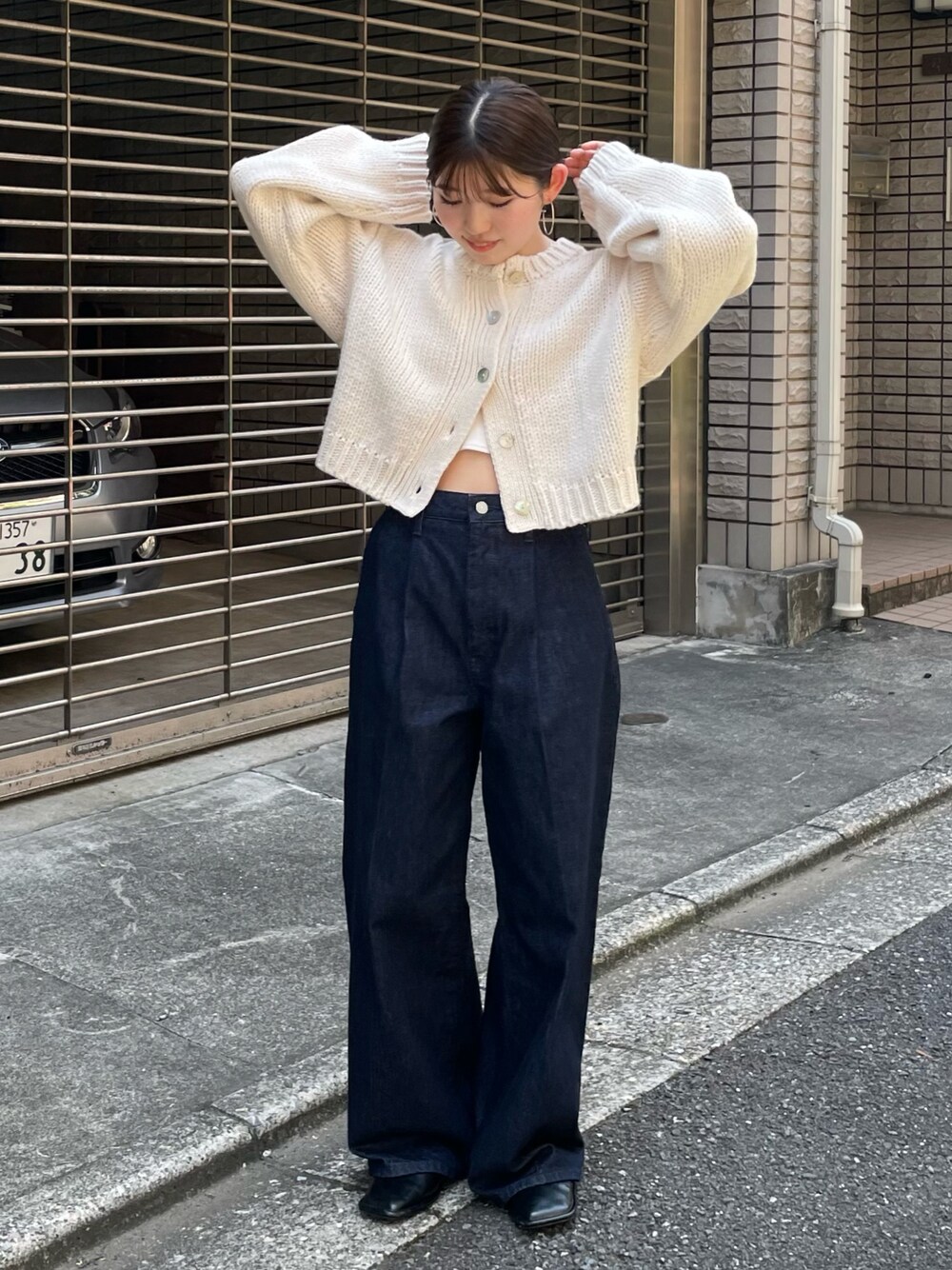 ブラック系のローファー、ブルー系のデニムパンツ、ホワイト系のカーディガン/ボレロを着用したレディースの秋コーディネートの1枚目の写真