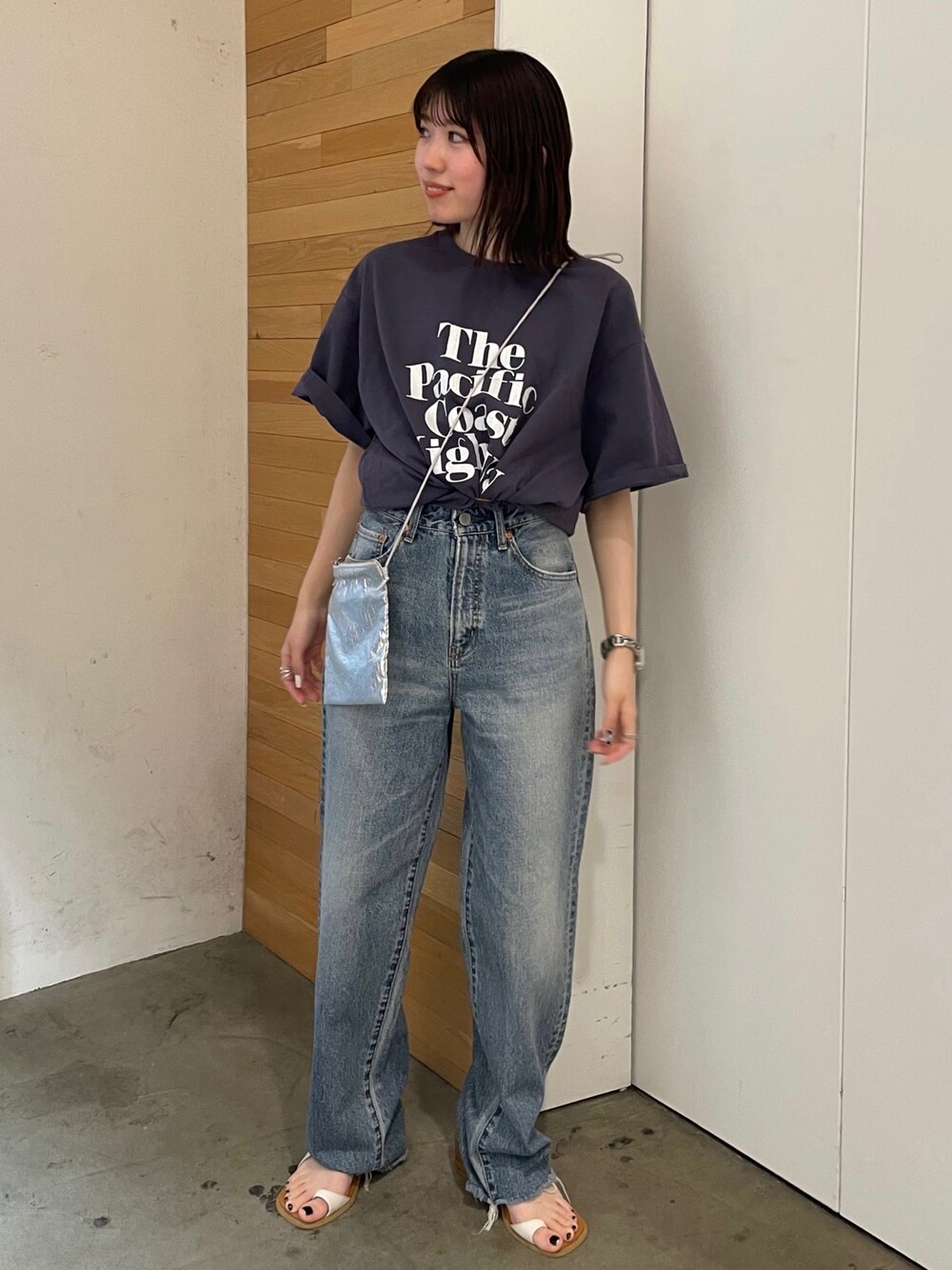 ホワイト系のサンダル、ブルー系のデニムパンツ、シルバー系のショルダーバッグを着用したレディースの春コーディネートの1枚目の写真