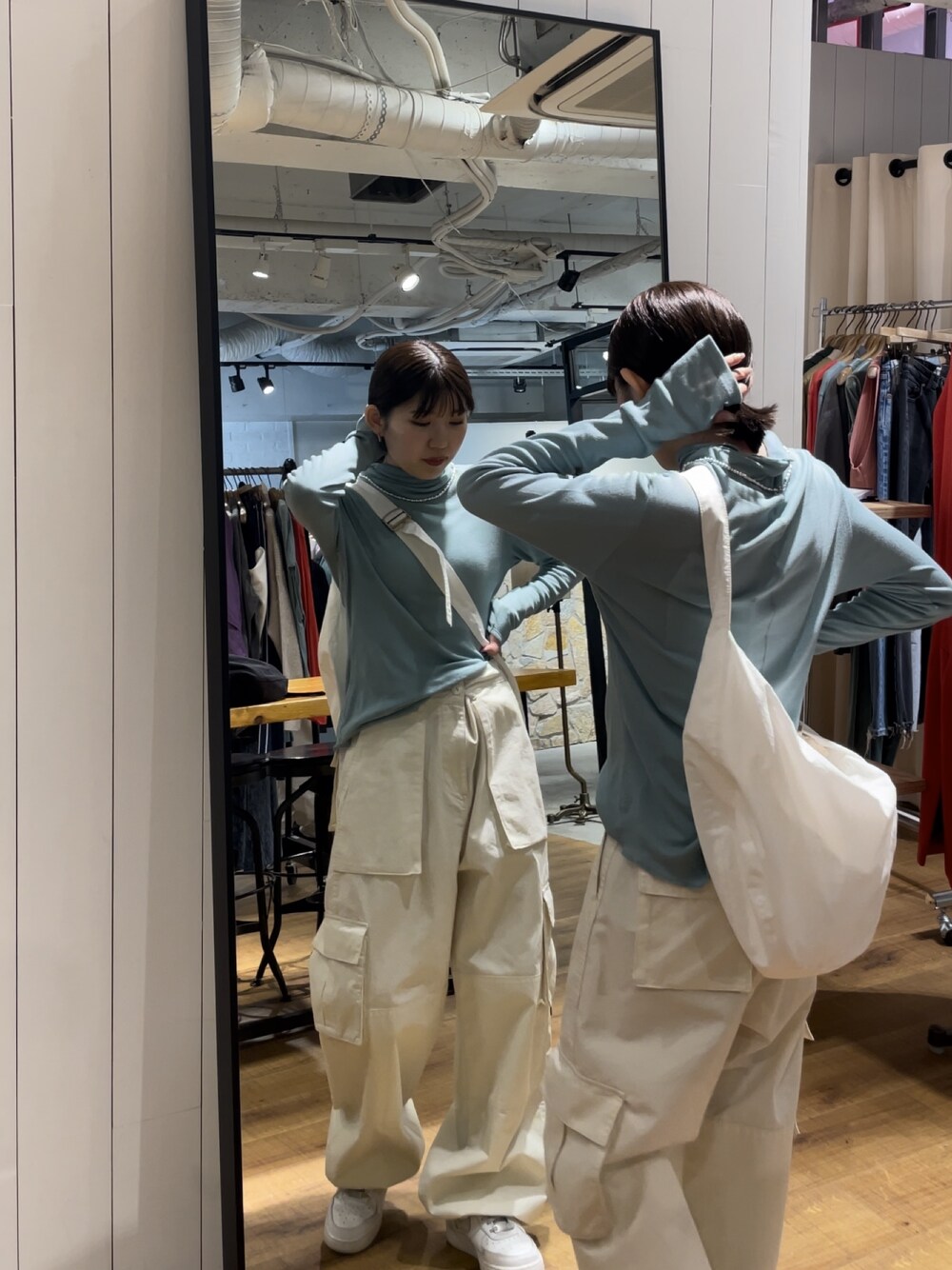 ホワイト系のカーゴパンツ、ホワイト系のショルダーバッグ、ブルー系のTシャツ/カットソーを着用したレディースの夏コーディネートの1枚目の写真