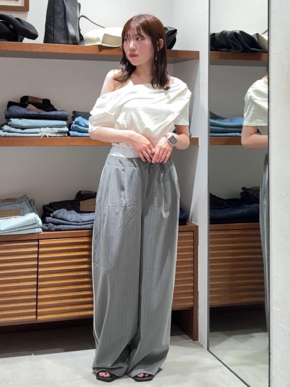 グレー系のその他パンツ、ブラック系のサンダル、ホワイト系のTシャツ/カットソーを着用したレディースの春コーディネートの1枚目の写真