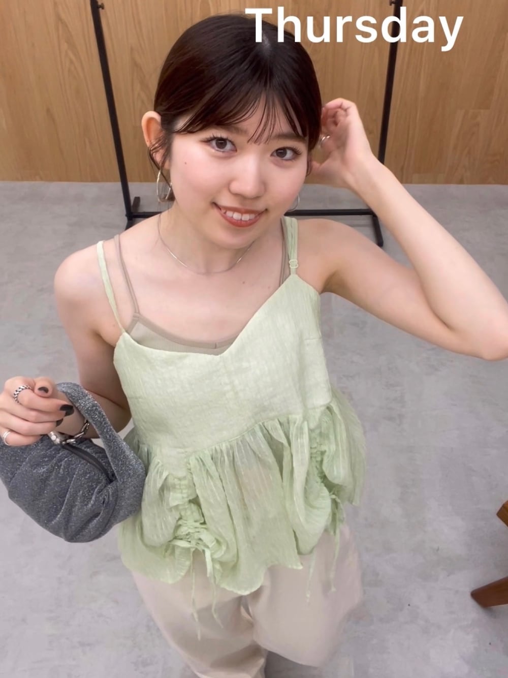 グレー系のキャミソール、ホワイト系のデニムパンツ、シルバー系のサンダルを着用したレディースの春コーディネートの1枚目の写真