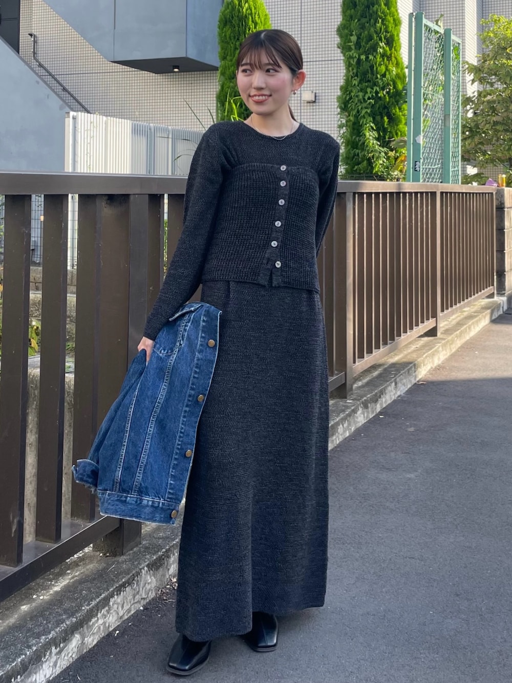 ブラック系のブーツ、ブラック系のワンピース、ブルー系のデニムジャケットを着用したレディースの冬コーディネートの1枚目の写真