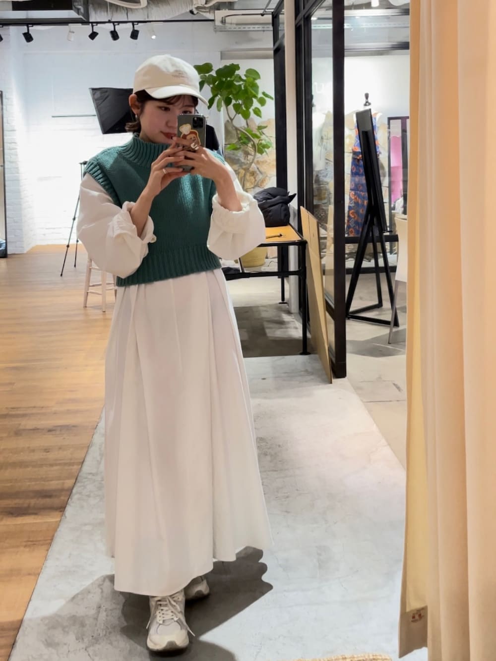 グリーン系のワンピース、ホワイト系のキャップを着用したレディースの春コーディネートの1枚目の写真