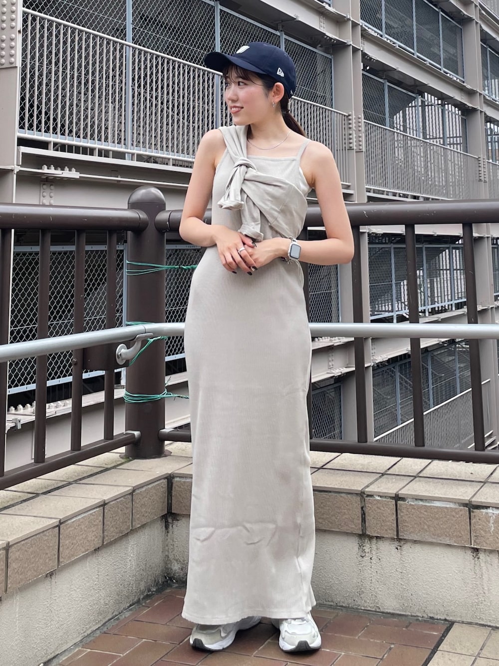 グレー系のワンピース、ブルー系のデニムジャケット、ブルー系のキャップを着用したレディースの夏コーディネートの1枚目の写真