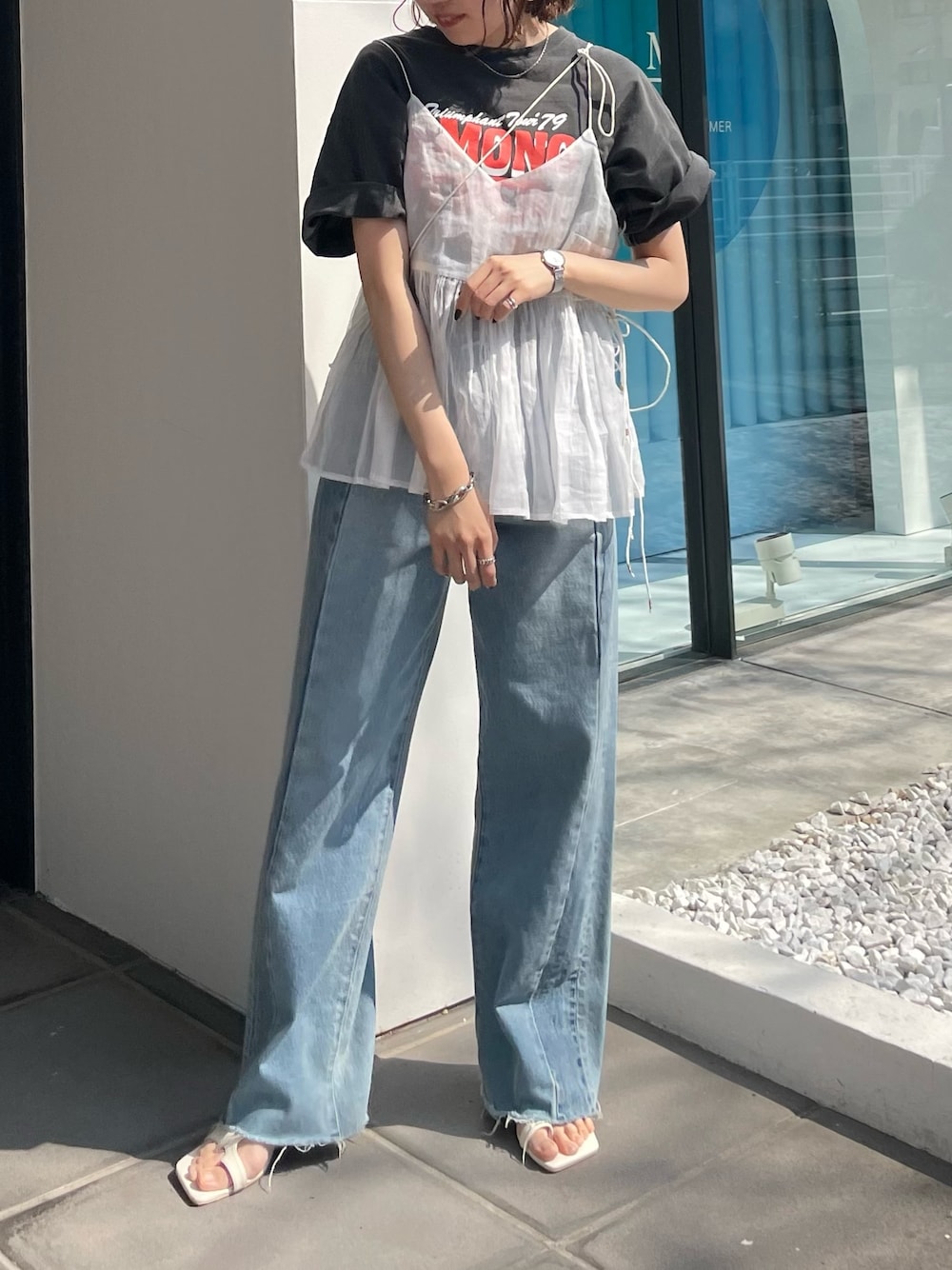 ブルー系のデニムパンツ、グレー系のTシャツ/カットソー、ホワイト系のショルダーバッグを着用したレディースの春コーディネートの1枚目の写真