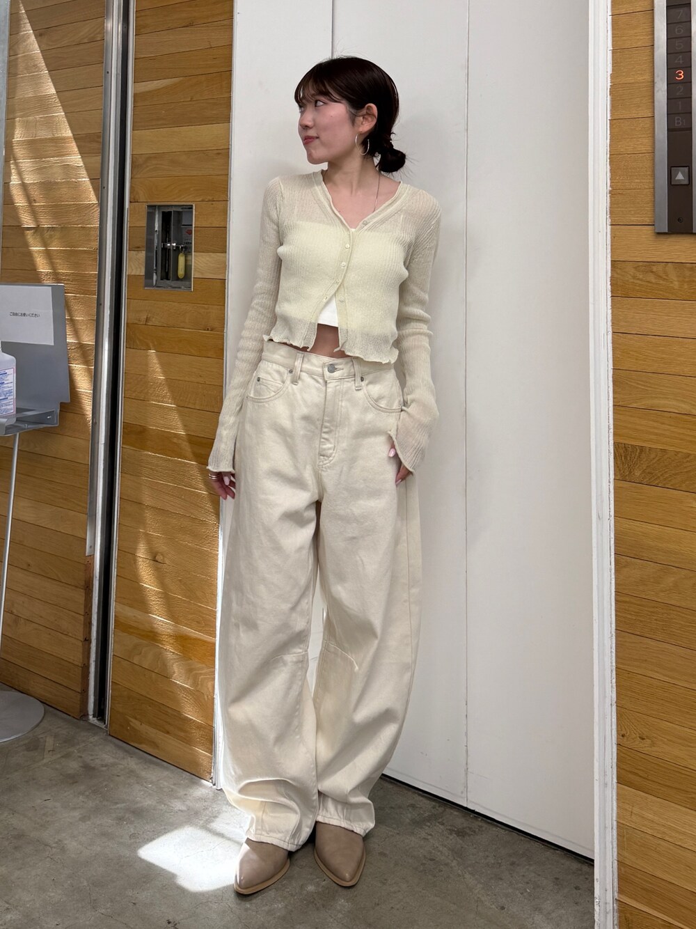 ホワイト系のデニムパンツ、ベージュ系のブーツ、ホワイト系のカーディガン/ボレロを着用したレディースの春コーディネートの1枚目の写真