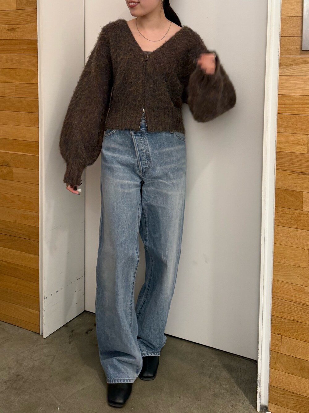ブルー系のデニムパンツ、ブラック系のブーツ、ブラウン系のカーディガン/ボレロを着用したレディースの冬コーディネートの1枚目の写真