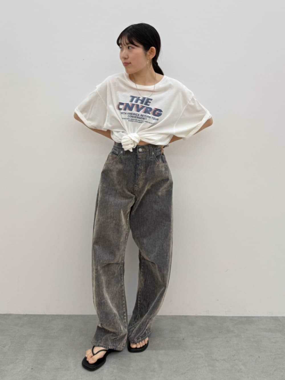 ブラック系のサンダル、ホワイト系のTシャツ/カットソー、ベージュ系のデニムパンツを着用したレディースの夏コーディネートの1枚目の写真