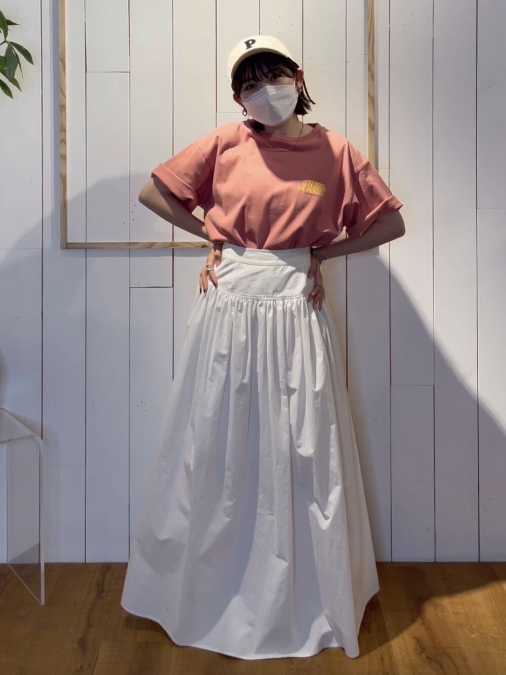 ホワイト系のスカート、ピンク系のTシャツ/カットソーを着用したレディースの春コーディネートの1枚目の写真