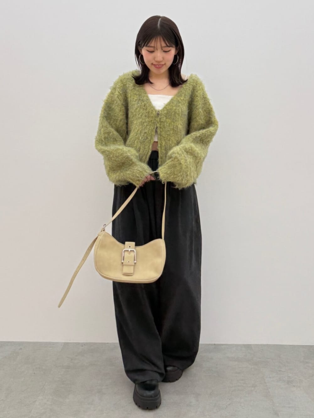 ベージュ系のハンドバッグ、ブラウン系のその他パンツ、イエロー系のニット/セーターを着用したレディースの秋コーディネートの1枚目の写真