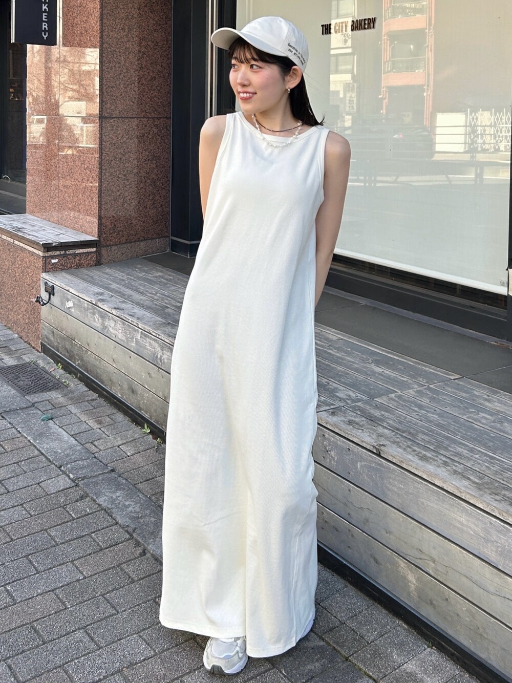 ホワイト系のワンピース、グレー系のカーディガン/ボレロ、ブルー系のネックレスを着用したレディースの夏コーディネートの1枚目の写真
