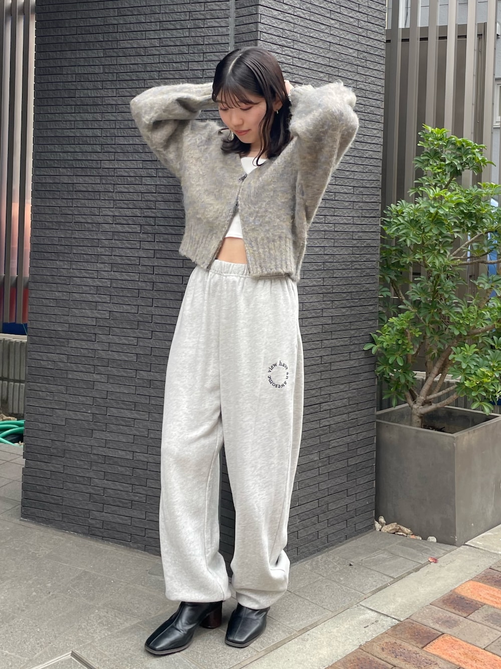 グレー系のスウェットパンツ、ブラック系のブーツ、グレー系のカーディガン/ボレロを着用したレディースの冬コーディネートの1枚目の写真