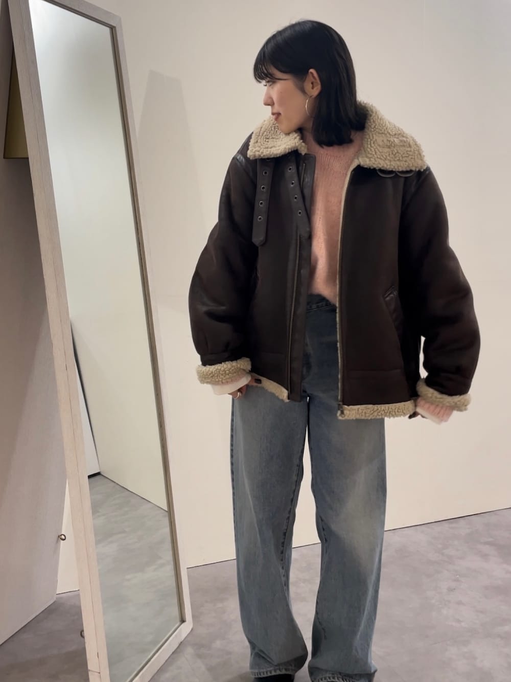 ブルー系のデニムパンツ、ブラック系のブーツ、ピンク系のニット/セーターを着用したレディースの冬コーディネートの1枚目の写真