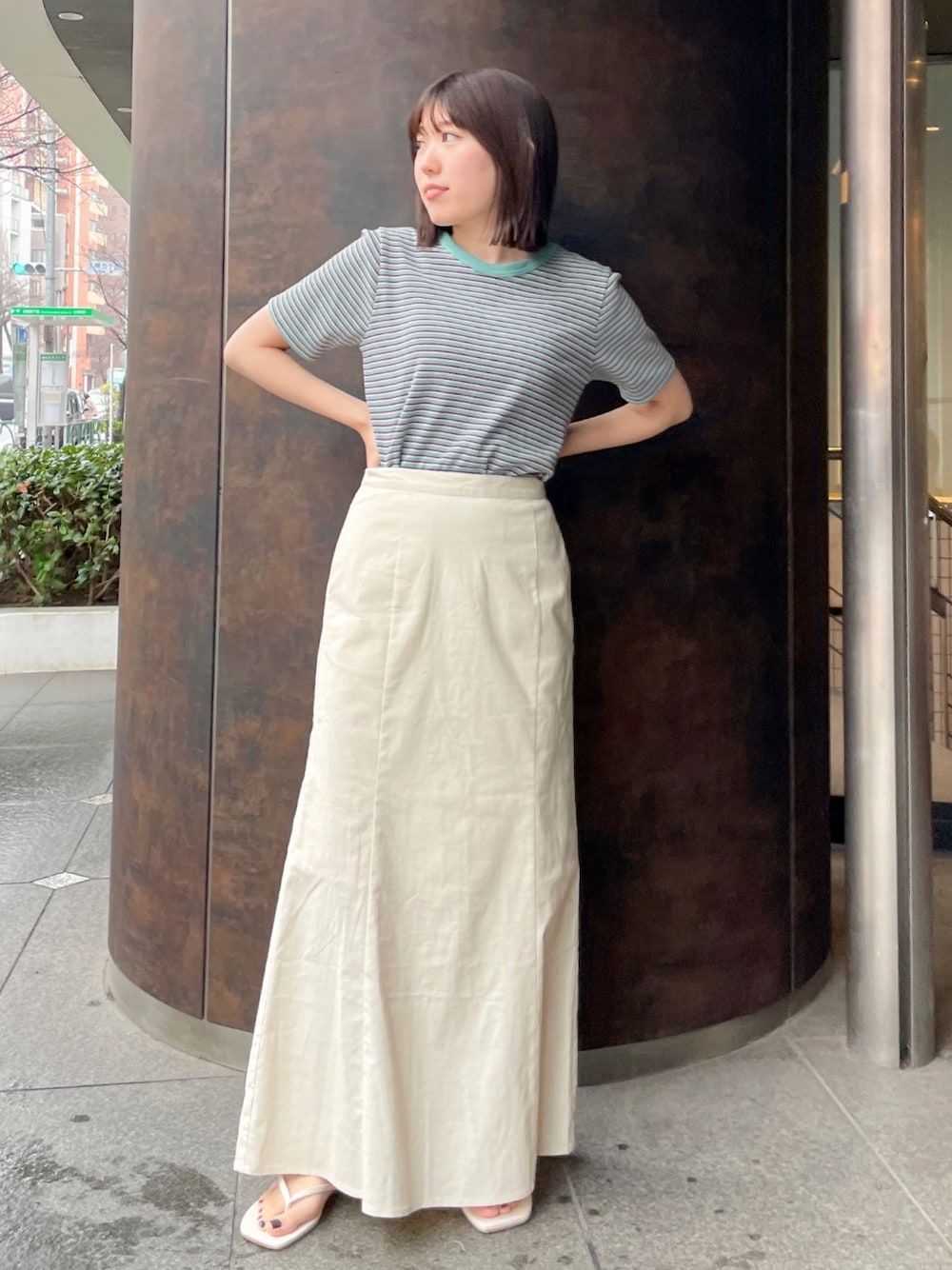 グリーン系のTシャツ/カットソー、ホワイト系のサンダル、ホワイト系のスカートを着用したレディースの春コーディネートの1枚目の写真