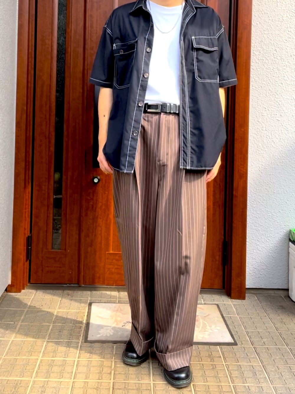 ホワイト系のTシャツ/カットソー、ブラウン系のスラックス、ブラック系のドレスシューズを着用したメンズの夏コーディネートの1枚目の写真