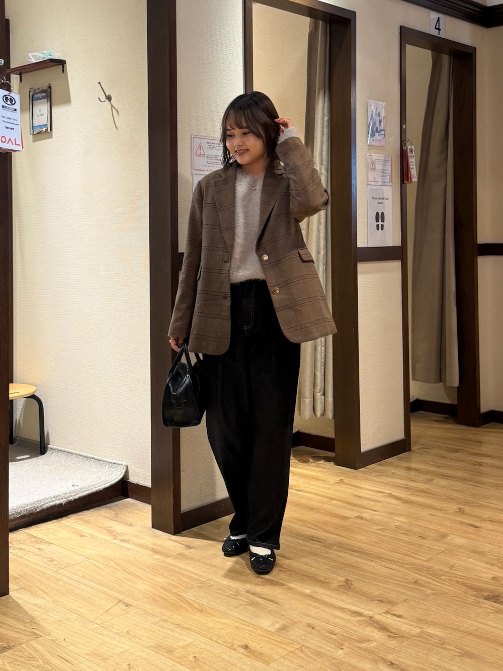 ベージュ系のニット/セーター、ブラック系のボストンバッグ、ブルー系のデニムパンツを着用したレディースの秋コーディネートの1枚目の写真