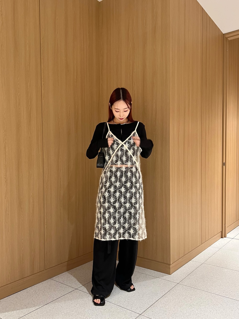 ブラック系のカーディガン/ボレロ、ホワイト系のキャミソール、ブラック系のその他パンツを着用したレディースの春コーディネートの1枚目の写真