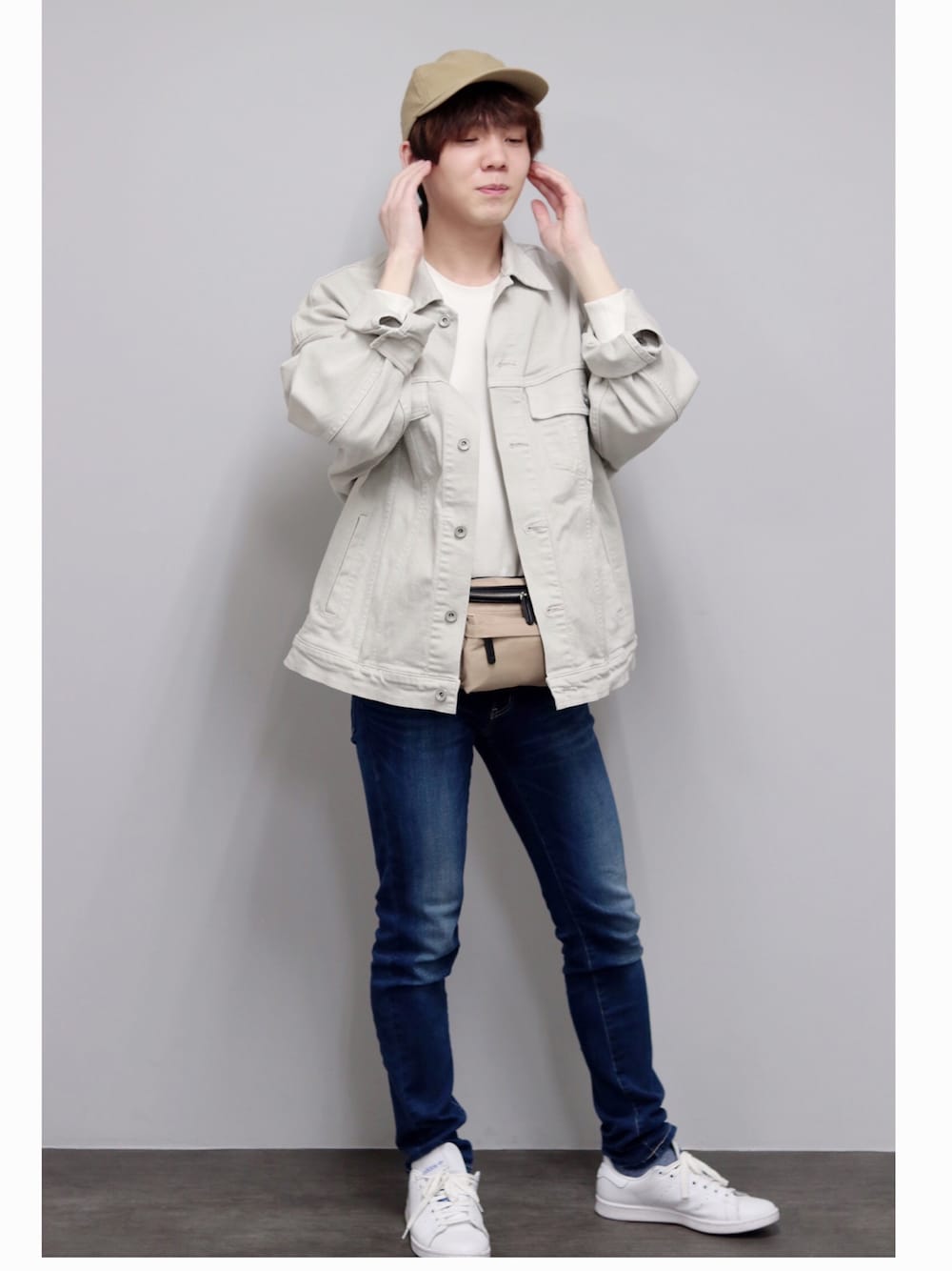 グレー系のボディバッグ/ウエストポーチ、ブルー系のデニムパンツ、ホワイト系のスニーカーを着用したメンズの春コーディネートの1枚目の写真