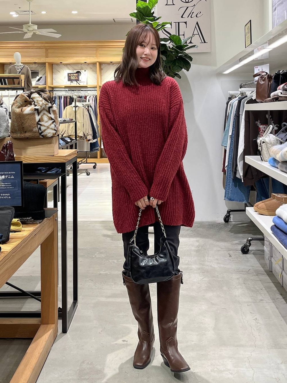 ブラック系のその他パンツ、ブラウン系のブーツ、レッド系のチュニックを着用したレディースの冬コーディネートの1枚目の写真