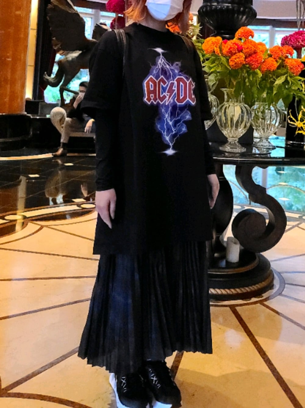 ブラック系のTシャツ/カットソー、ブラック系のスカート、ブラック系のスニーカーを着用したレディースの秋コーディネートの1枚目の写真