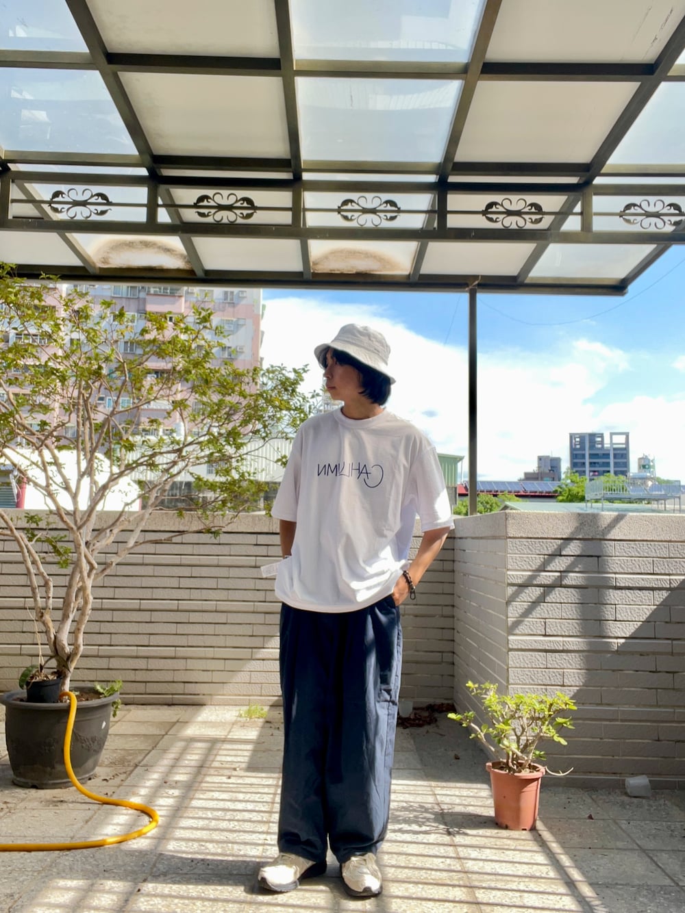 ブルー系のチノパンツ、ホワイト系のTシャツ/カットソー、ホワイト系のスニーカーを着用したメンズの夏コーディネートの1枚目の写真