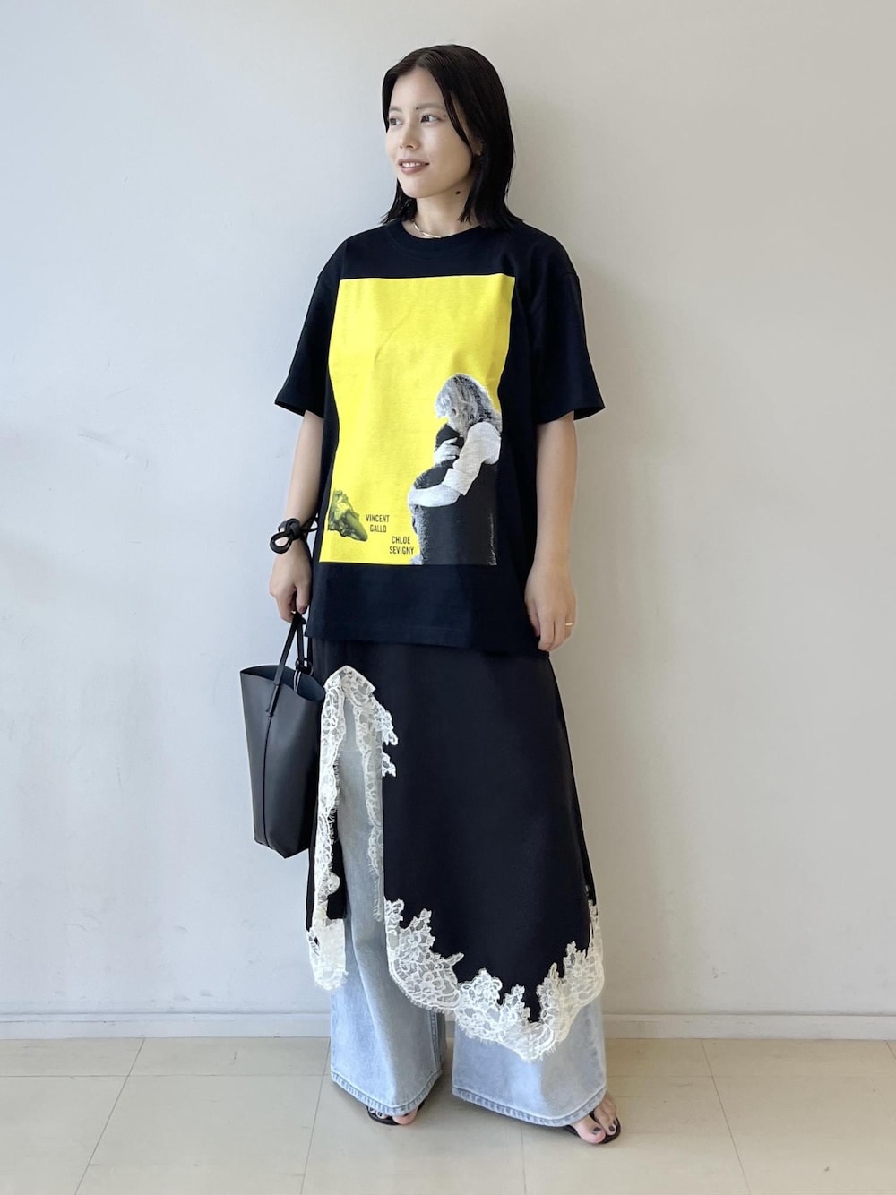 ブラック系のスカート、ブラック系のショルダーバッグ、グレー系のTシャツ/カットソーを着用したレディースの夏コーディネートの1枚目の写真