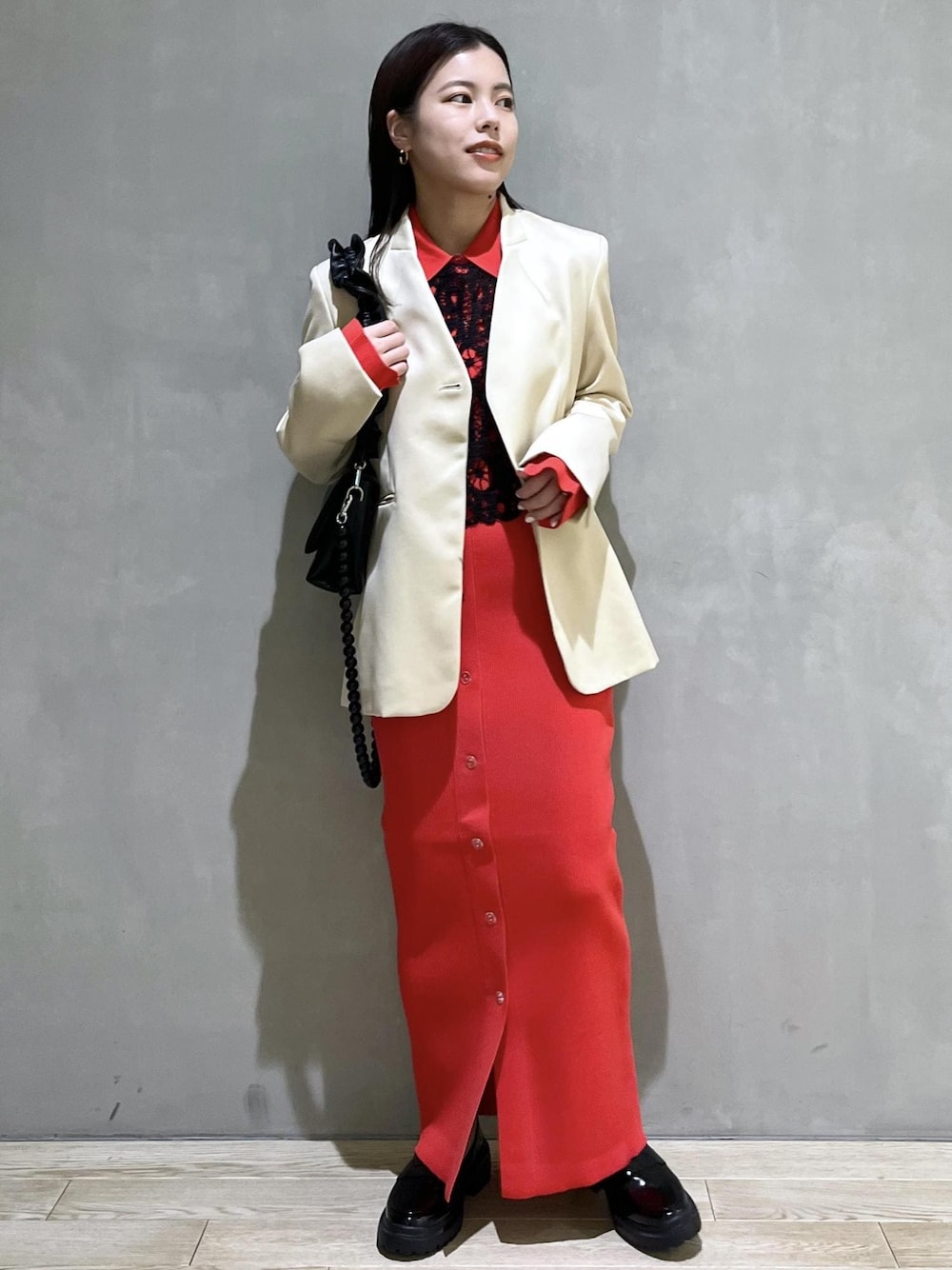 ブラック系のローファー、レッド系のスカート、レッド系のカーディガン/ボレロを着用したレディースの冬コーディネートの1枚目の写真