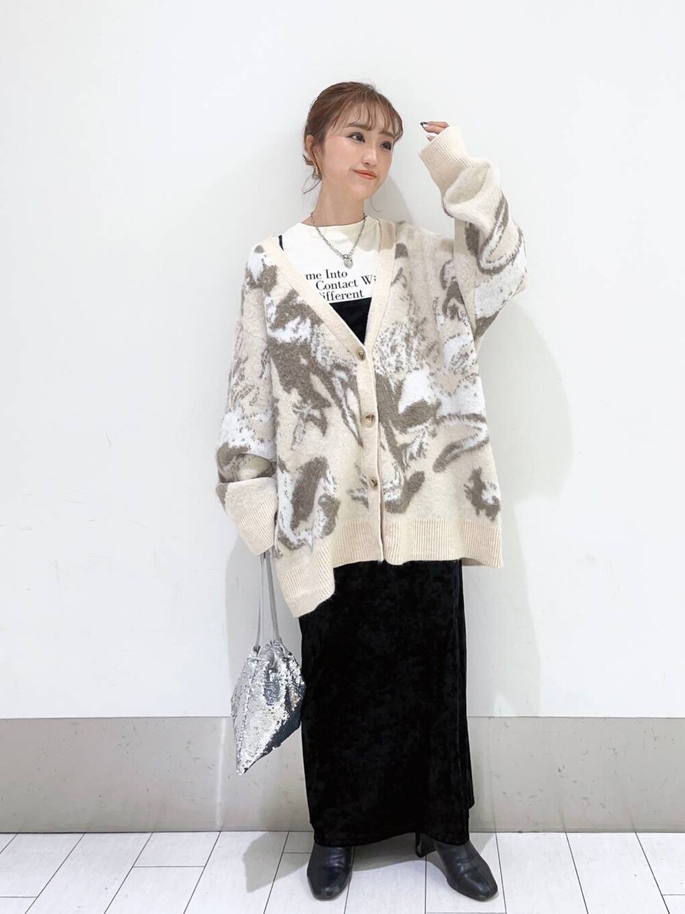 ブラック系のブーツ、グレー系のワンピース、シルバー系のハンドバッグを着用したレディースの冬コーディネートの1枚目の写真