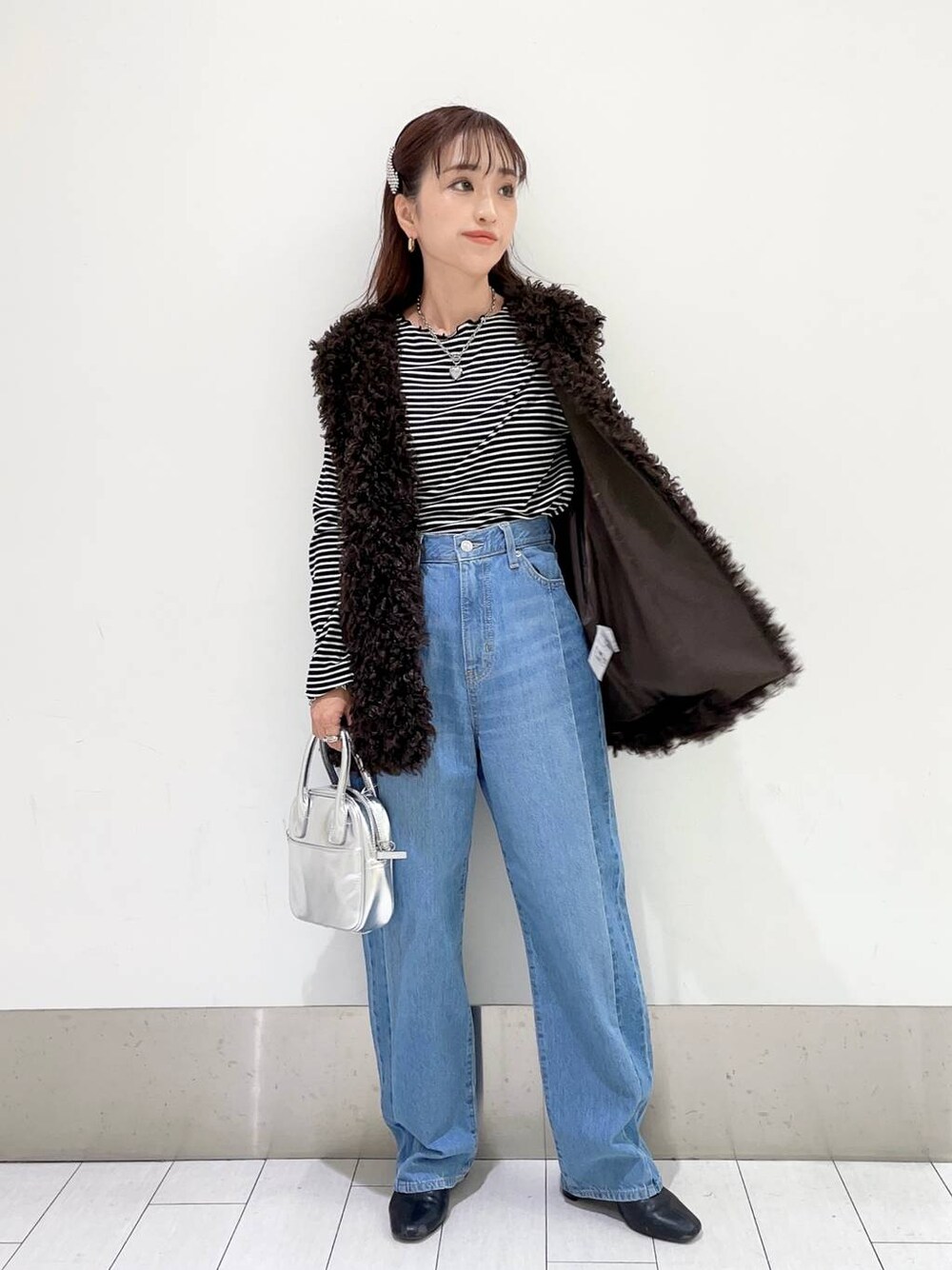 ブラック系のTシャツ/カットソー、ブルー系のデニムパンツ、ブラック系のブーツを着用したレディースの秋コーディネートの1枚目の写真