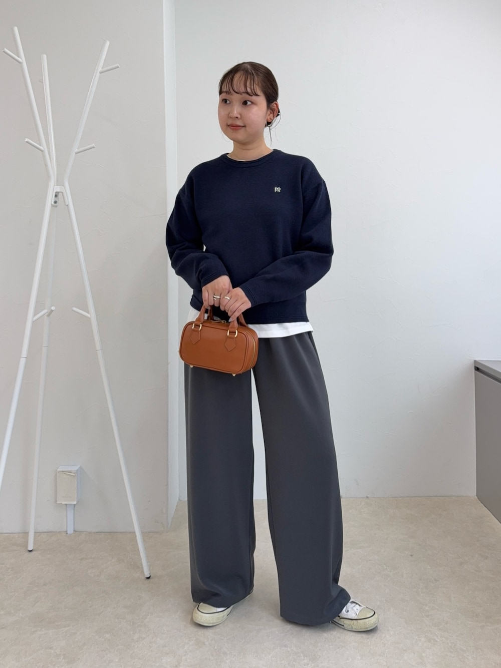 ブルー系のニット/セーター、グレー系のその他パンツ、イエロー系のショルダーバッグを着用したレディースの秋コーディネートの1枚目の写真