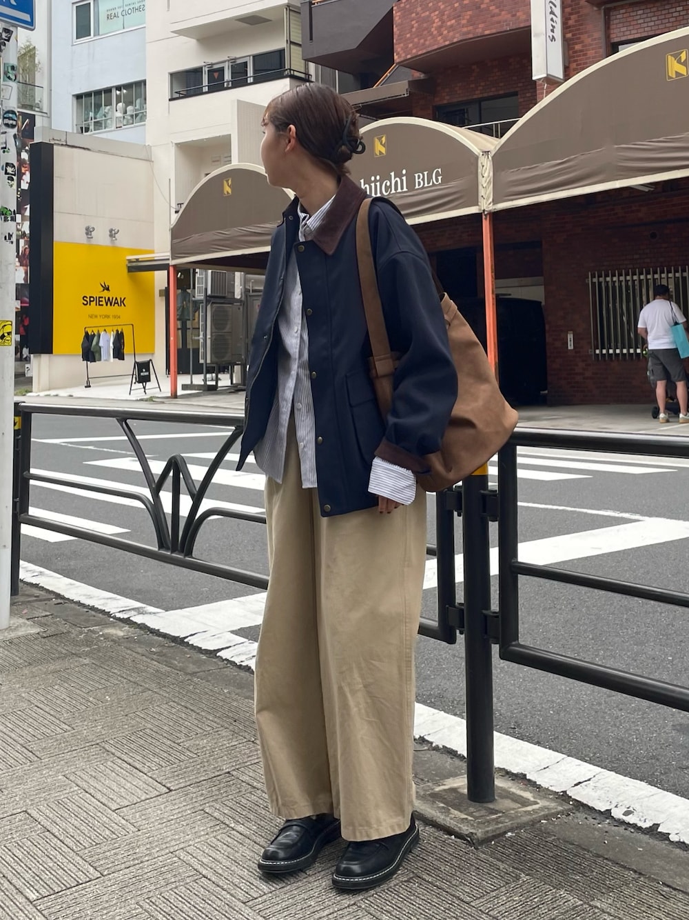 ベージュ系のチノパンツ、ブルー系のブルゾン、ブラウン系のショルダーバッグを着用したレディースの秋コーディネートの1枚目の写真