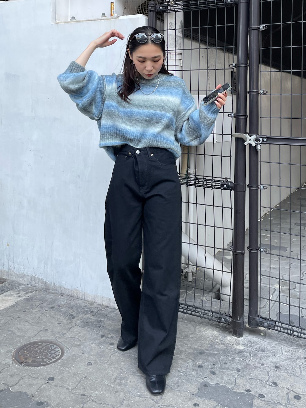 ブラック系のデニムパンツ、ブルー系のニット/セーターを着用したレディースの秋コーディネートの1枚目の写真