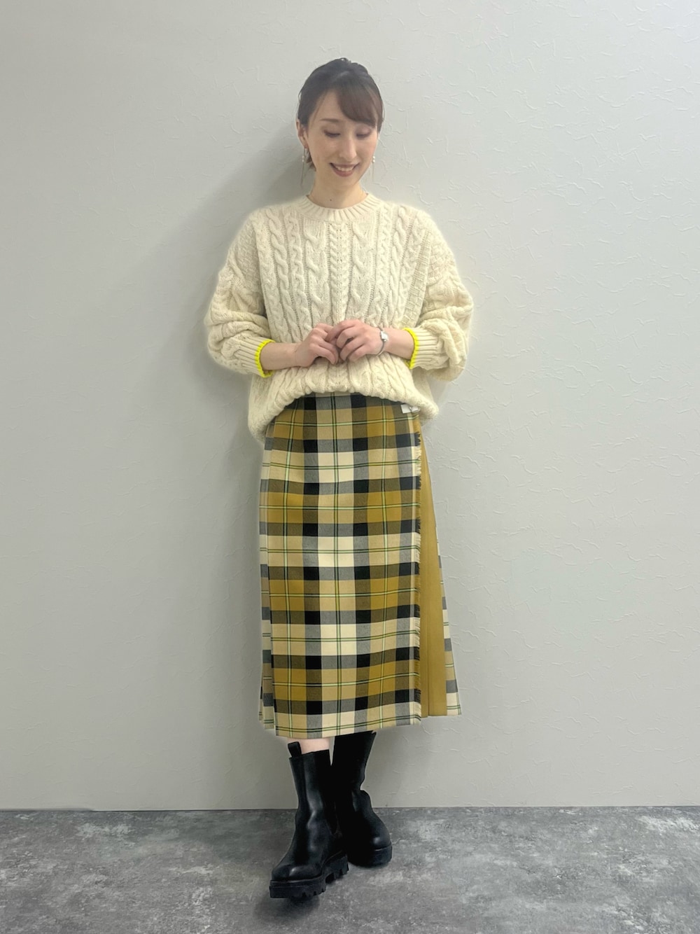 ホワイト系のニット/セーター、ベージュ系のスカート、ブラック系のブーツを着用したレディースの冬コーディネートの1枚目の写真