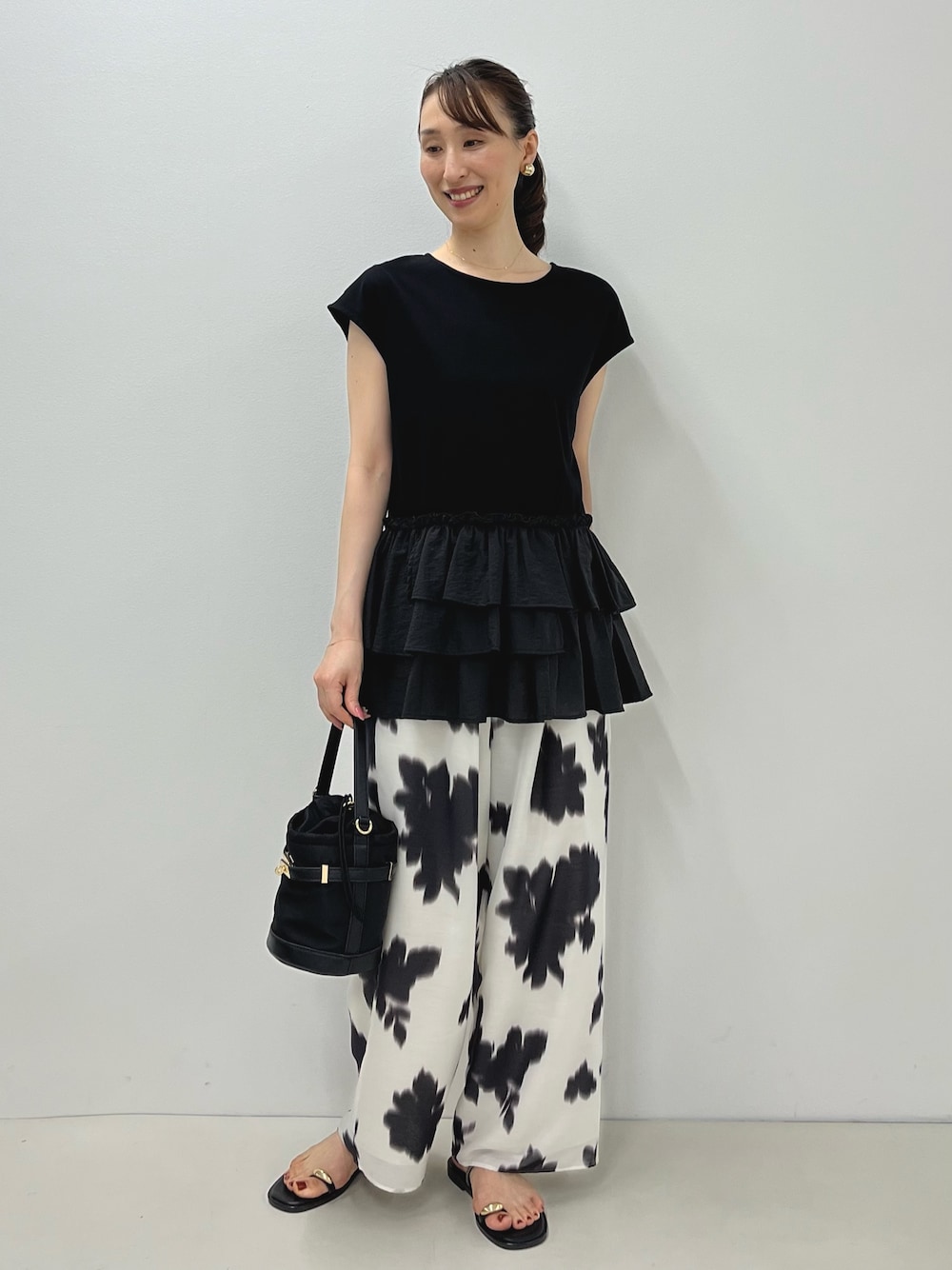 ブラック系のサンダル、ブラック系のTシャツ/カットソー、ホワイト系のその他パンツを着用したレディースの夏コーディネートの1枚目の写真