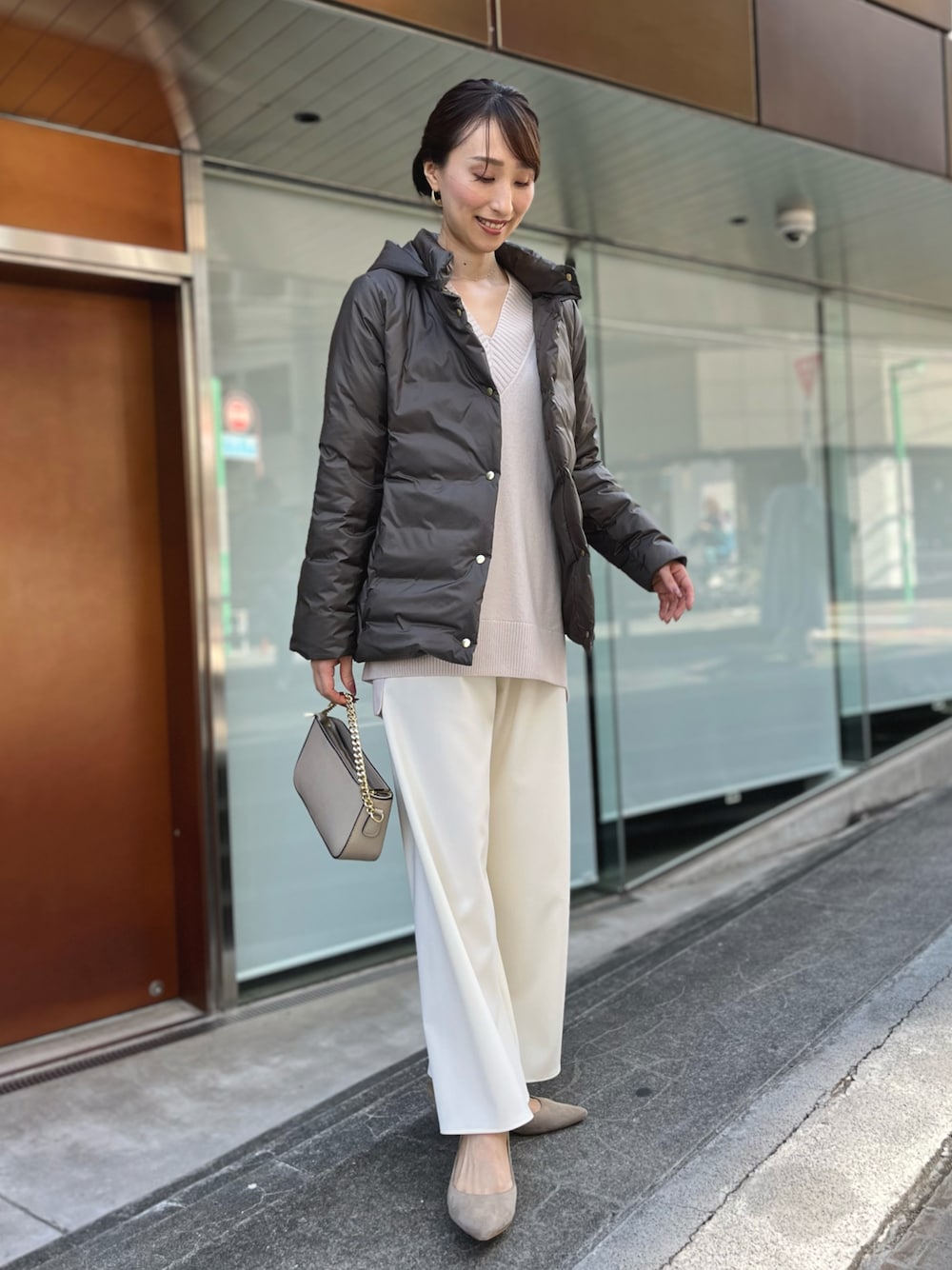 グリーン系のダウンジャケット/コート、ベージュ系のニット/セーター、ホワイト系のその他パンツを着用したレディースの秋コーディネートの1枚目の写真