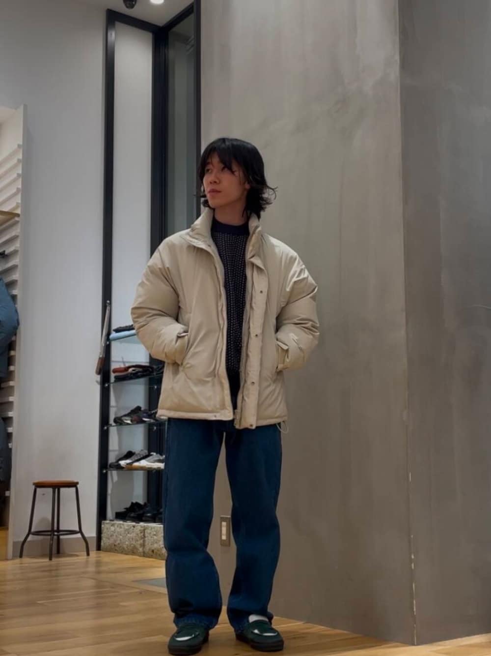 ブルー系のデニムパンツ、ブルー系のニット/セーター、ホワイト系のブルゾンを着用したメンズの冬コーディネートの1枚目の写真