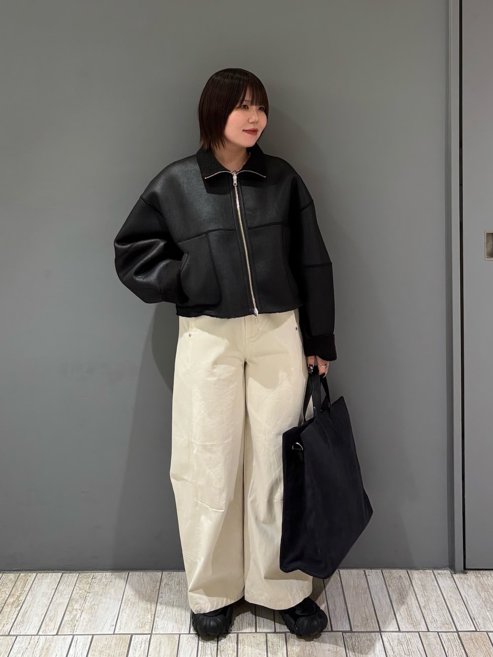 ブラック系のその他アウター、ホワイト系のその他パンツ、グレー系のトートバッグを着用したレディースの冬コーディネートの1枚目の写真