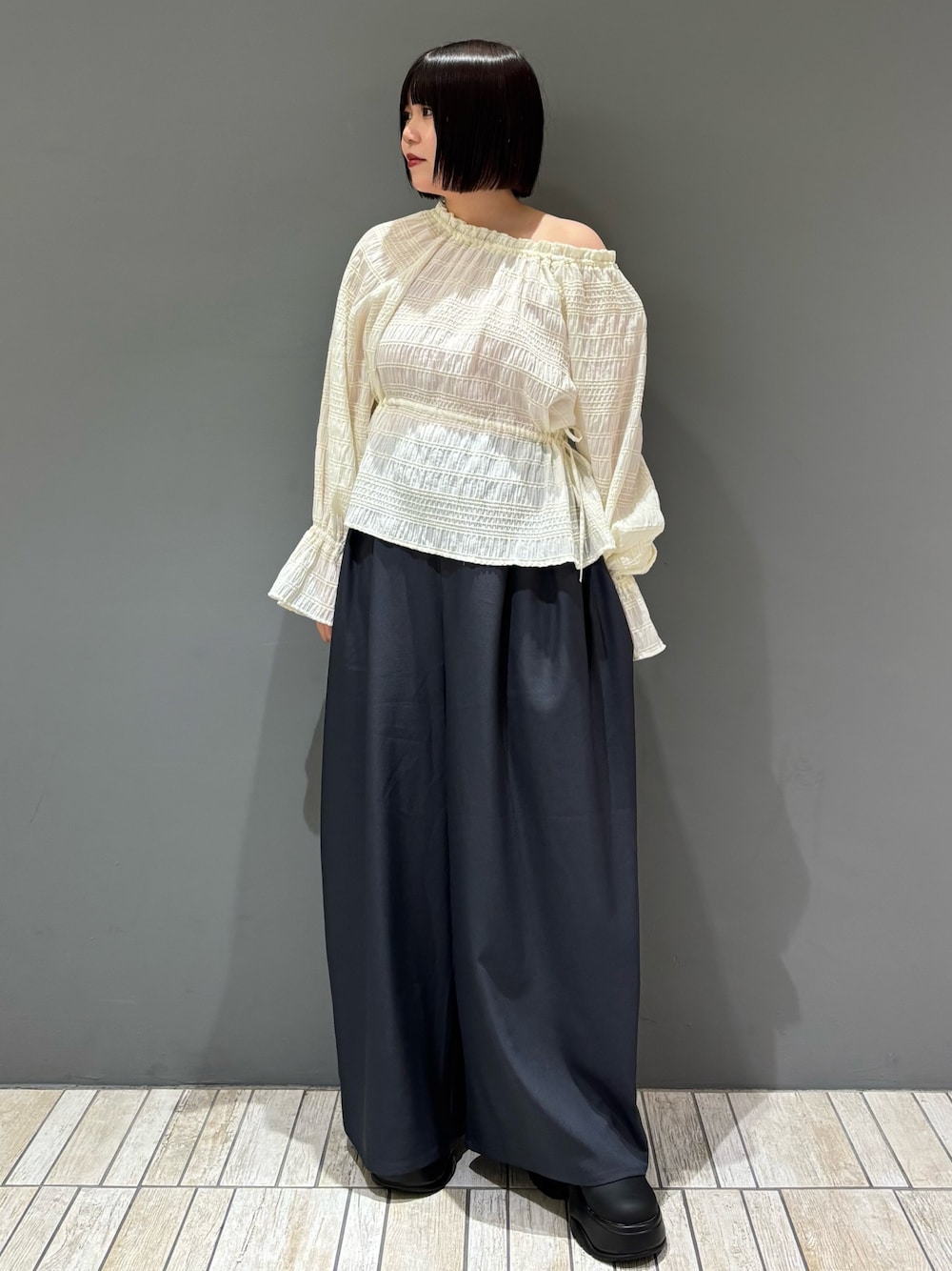 グレー系のその他パンツ、ホワイト系のシャツ/ブラウス、ブラック系のサンダルを着用したレディースの冬コーディネートの1枚目の写真