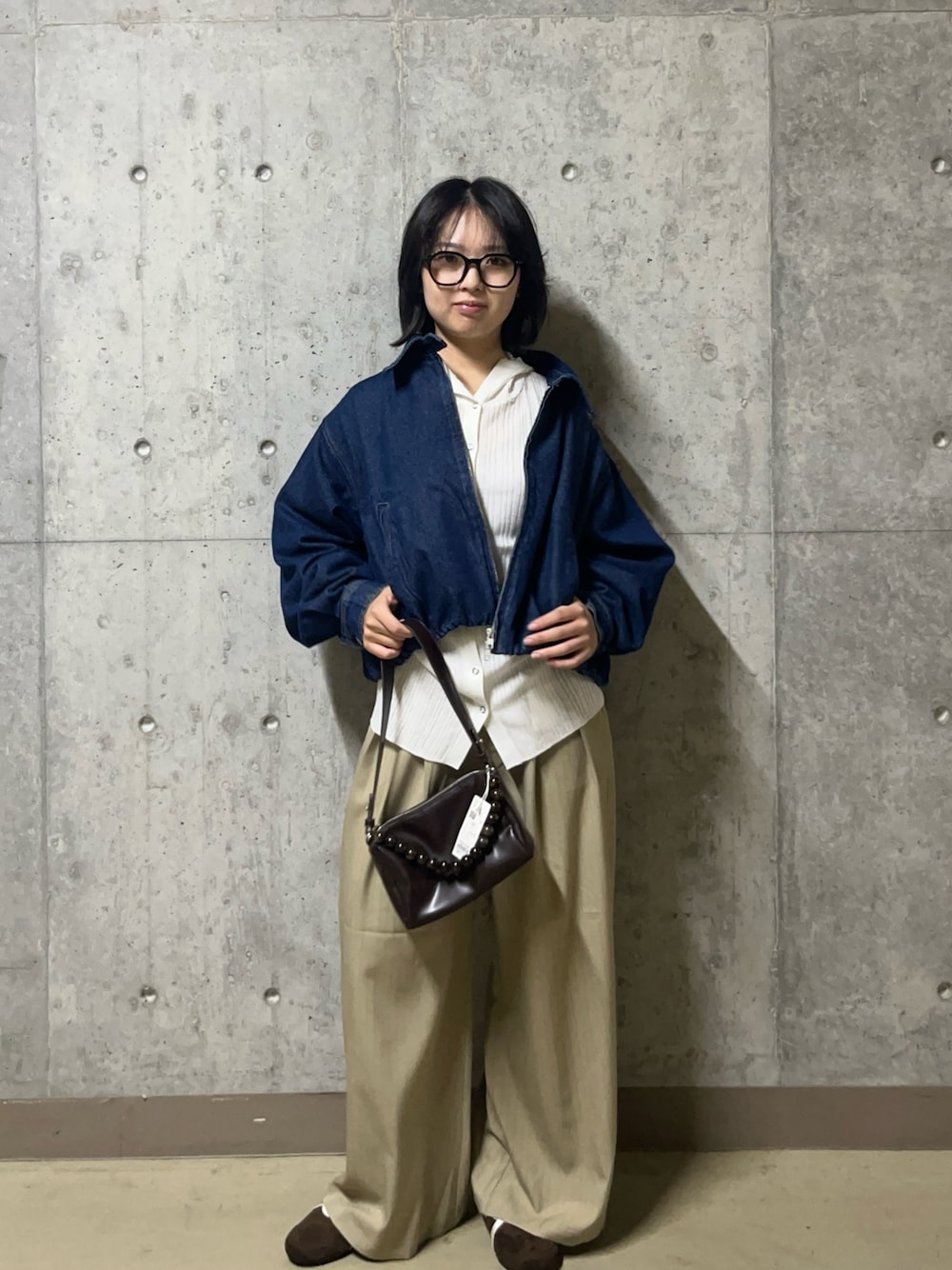 ブルー系のデニムジャケット、ホワイト系のニット/セーター、ベージュ系のその他パンツを着用したレディースの秋コーディネートの1枚目の写真