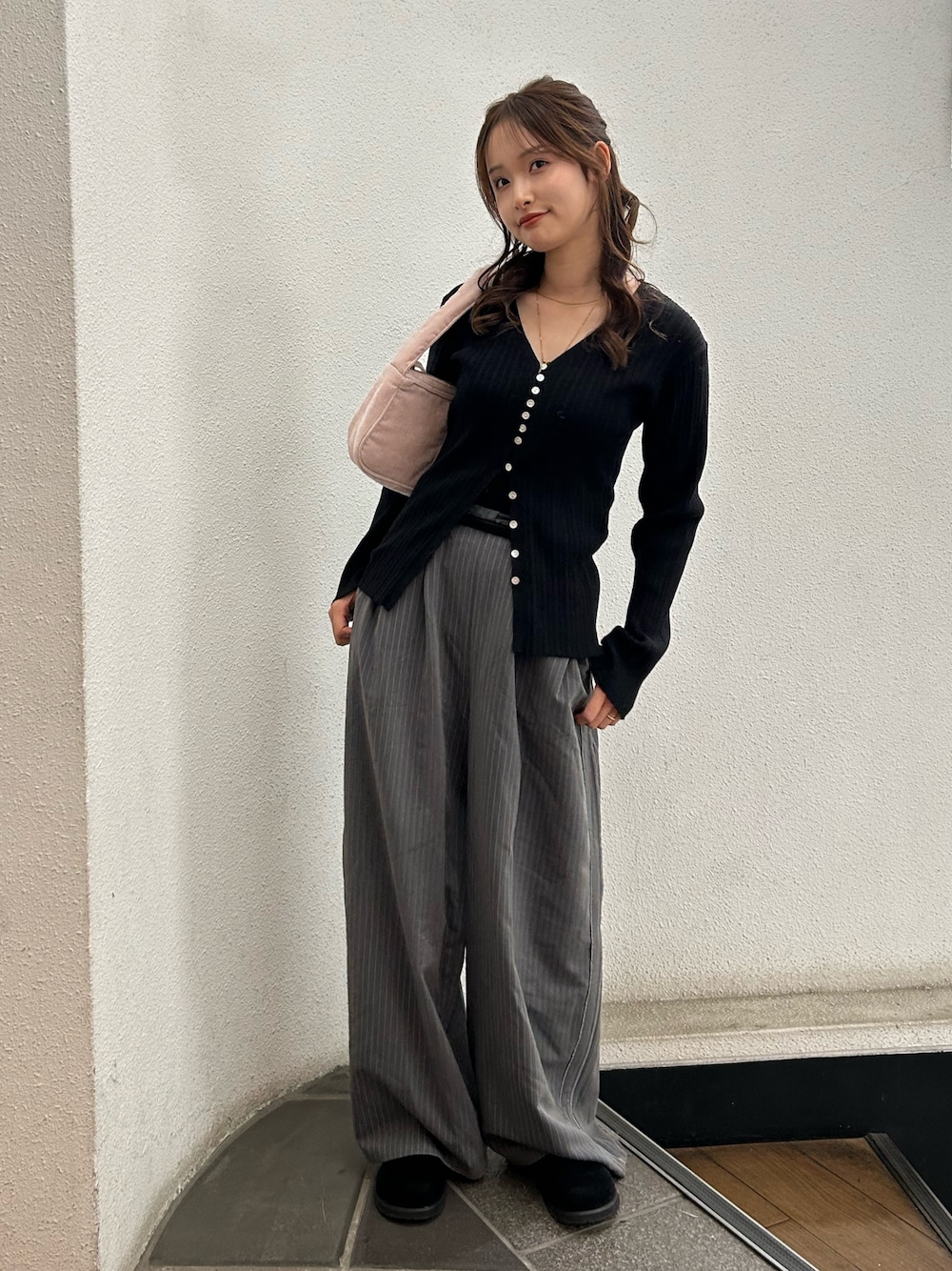 グレー系のその他パンツ、ブラック系のスリッポン、ピンク系のハンドバッグを着用したレディースの冬コーディネートの1枚目の写真